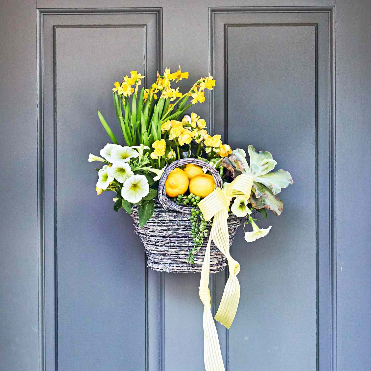 Hanging basket on front door with daffodils, violas, and succulents