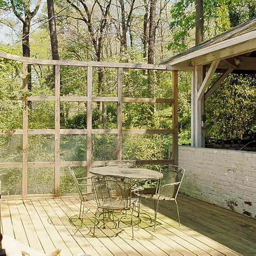 old backyard deck with wooden square scaffolding on the edge and outdoor table and chairs