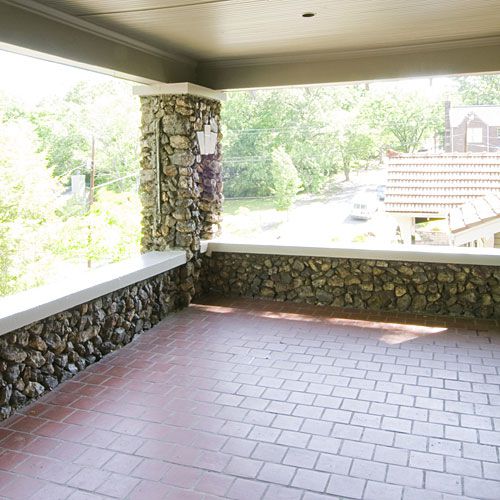 bare front porch with red tile and a stone ledge around the perimeter